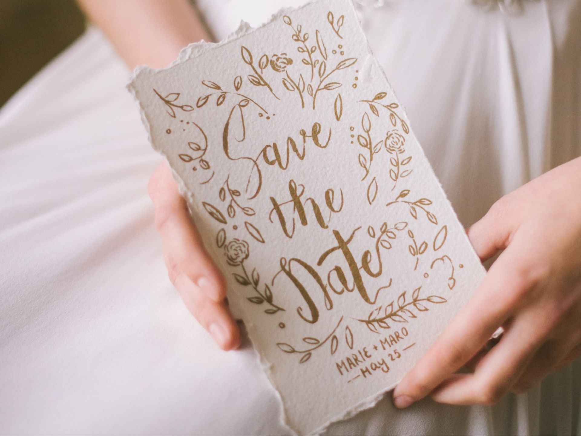 A bride holding her save the date cards.
