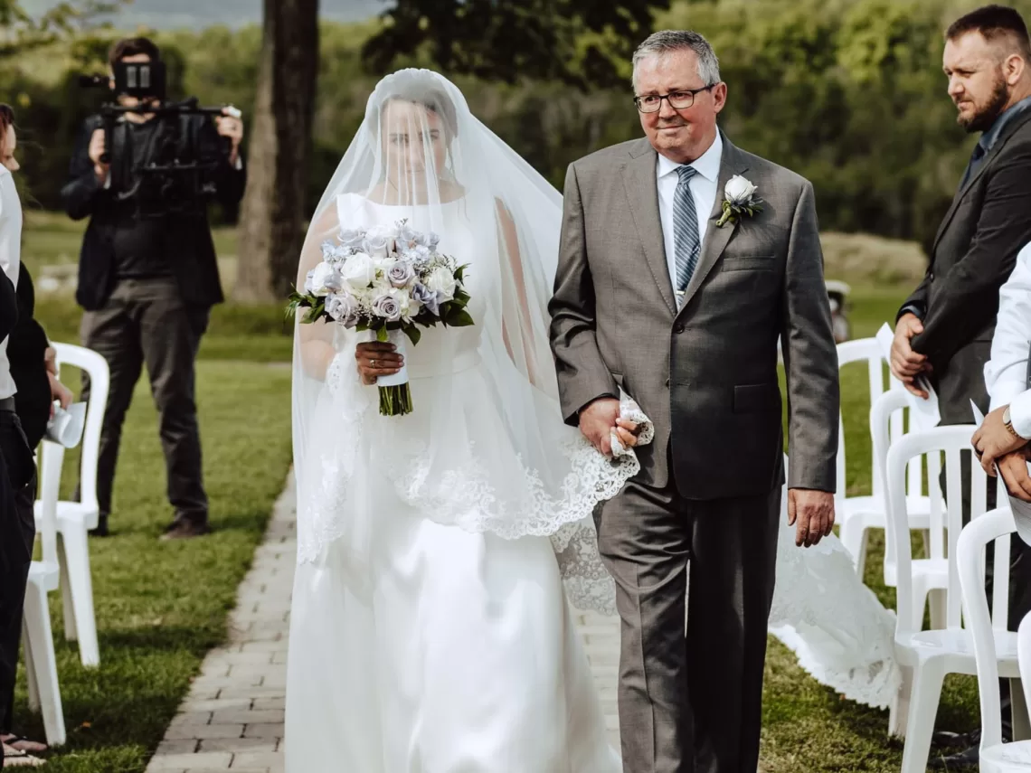 A bride walking down the aisle with her dad.