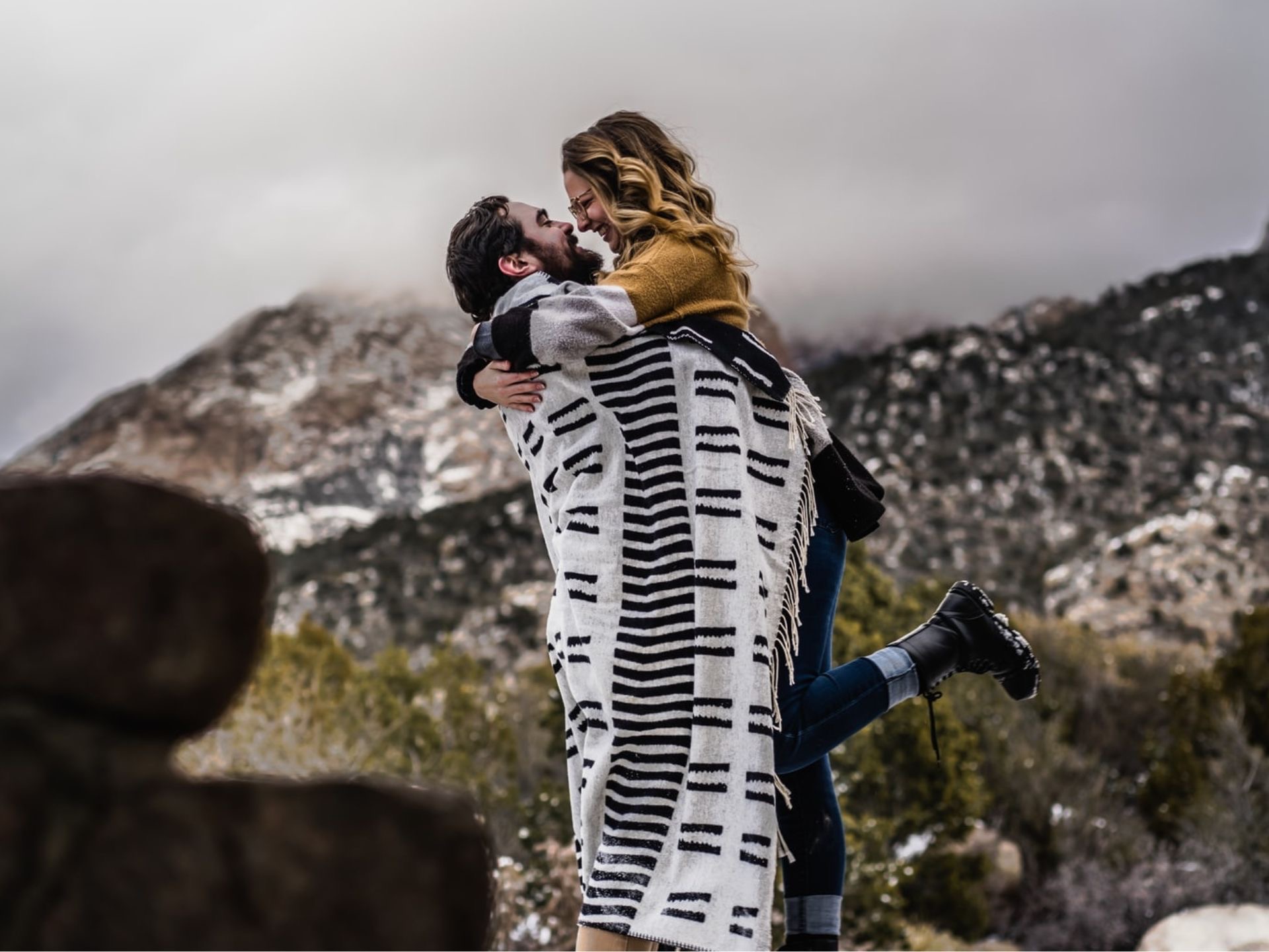 A couple hugging in the mountains.