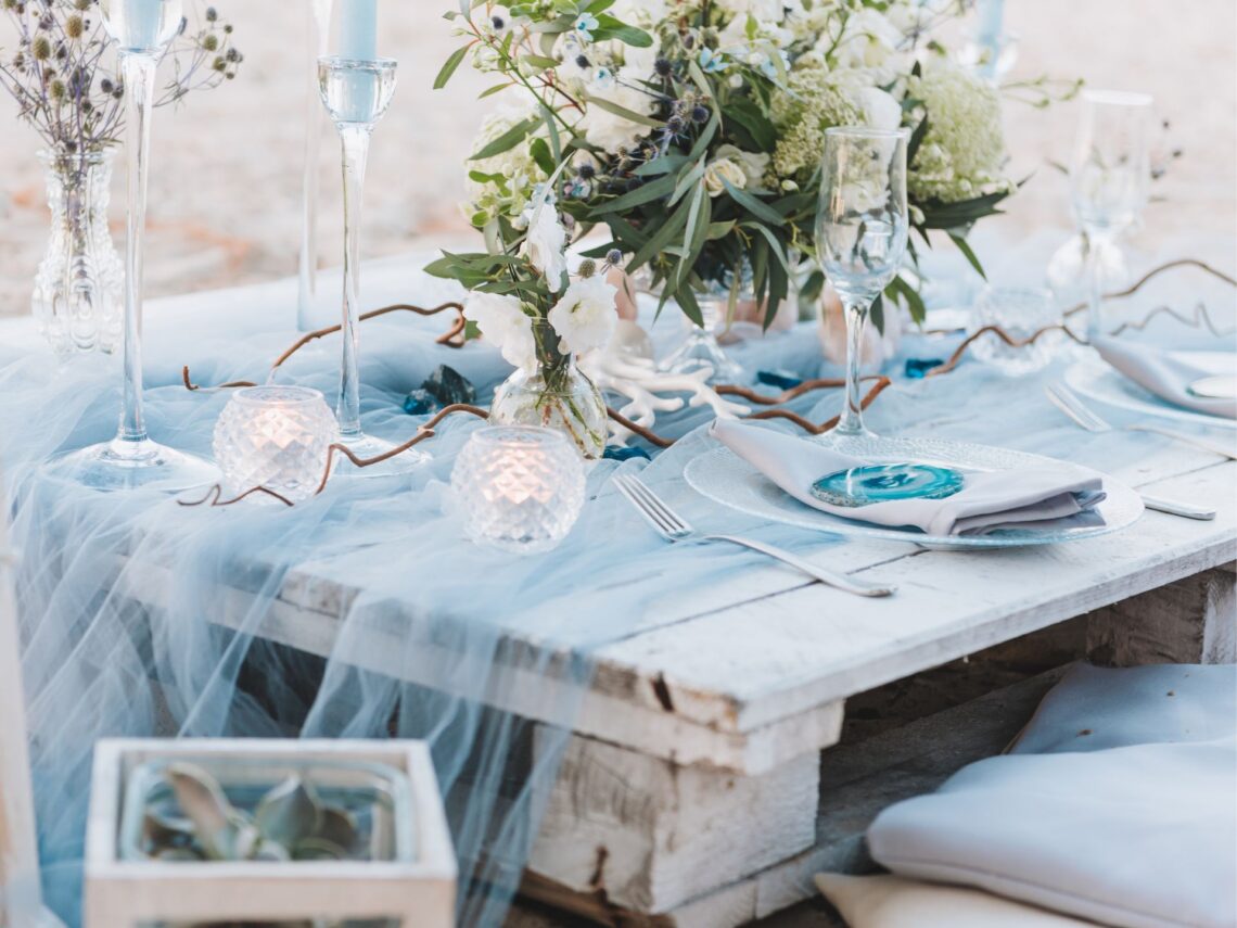 A wedding table with blue ribbon on top.