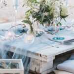 A wedding table with blue ribbon on top.