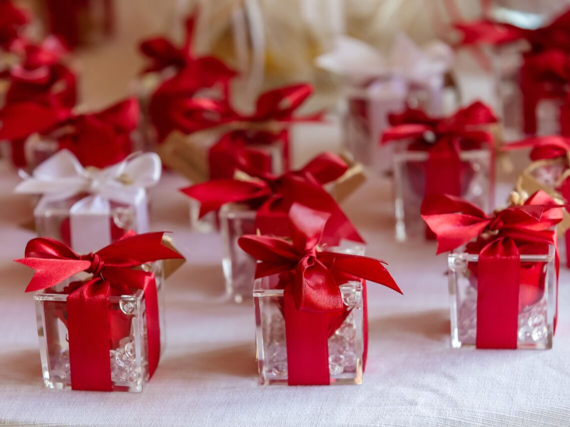 A table with mini red gifts on top.