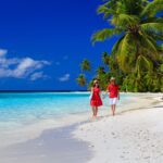 A couple walking on the beach together.