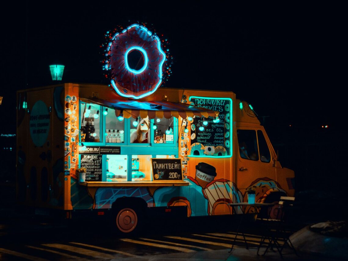 A photo of a donut food truck at night.