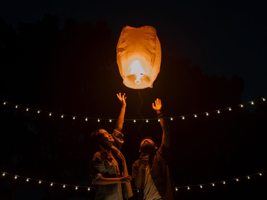 A couple releasing a lantern into the sky.