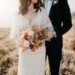 A bride holding rustic orange wedding bouquet.