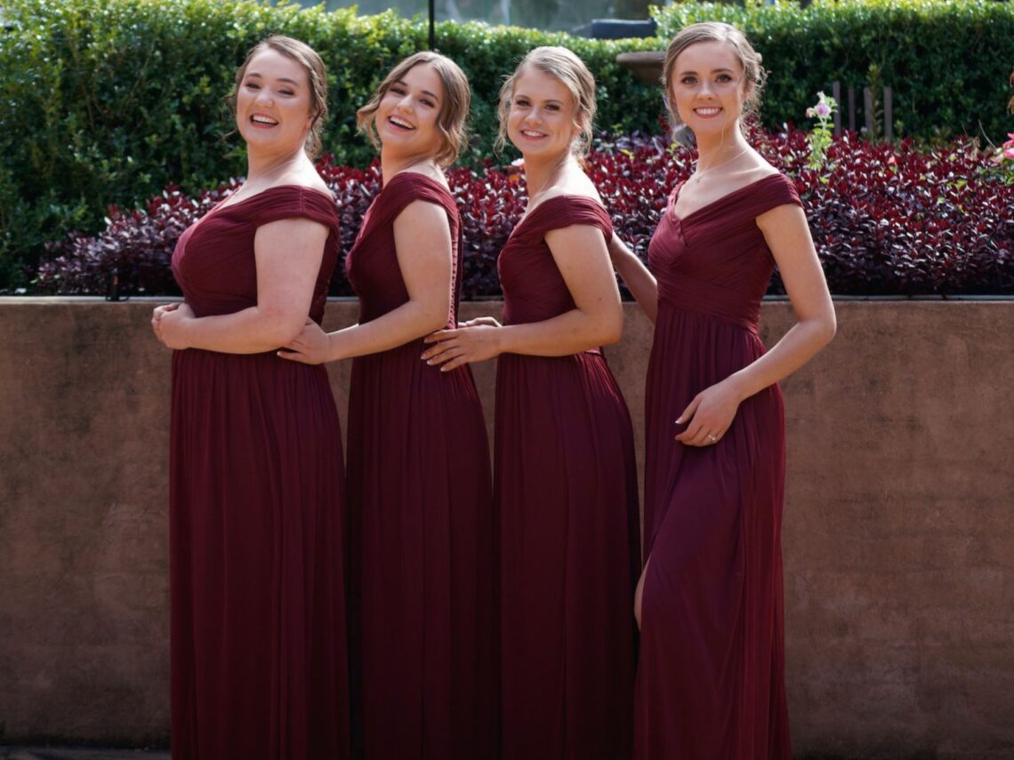 Bridesmaids wearing burgundy colored dresses.