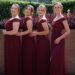 Bridesmaids wearing burgundy colored dresses.