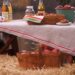 A picnic table with apples, apple donuts, and apple cider.