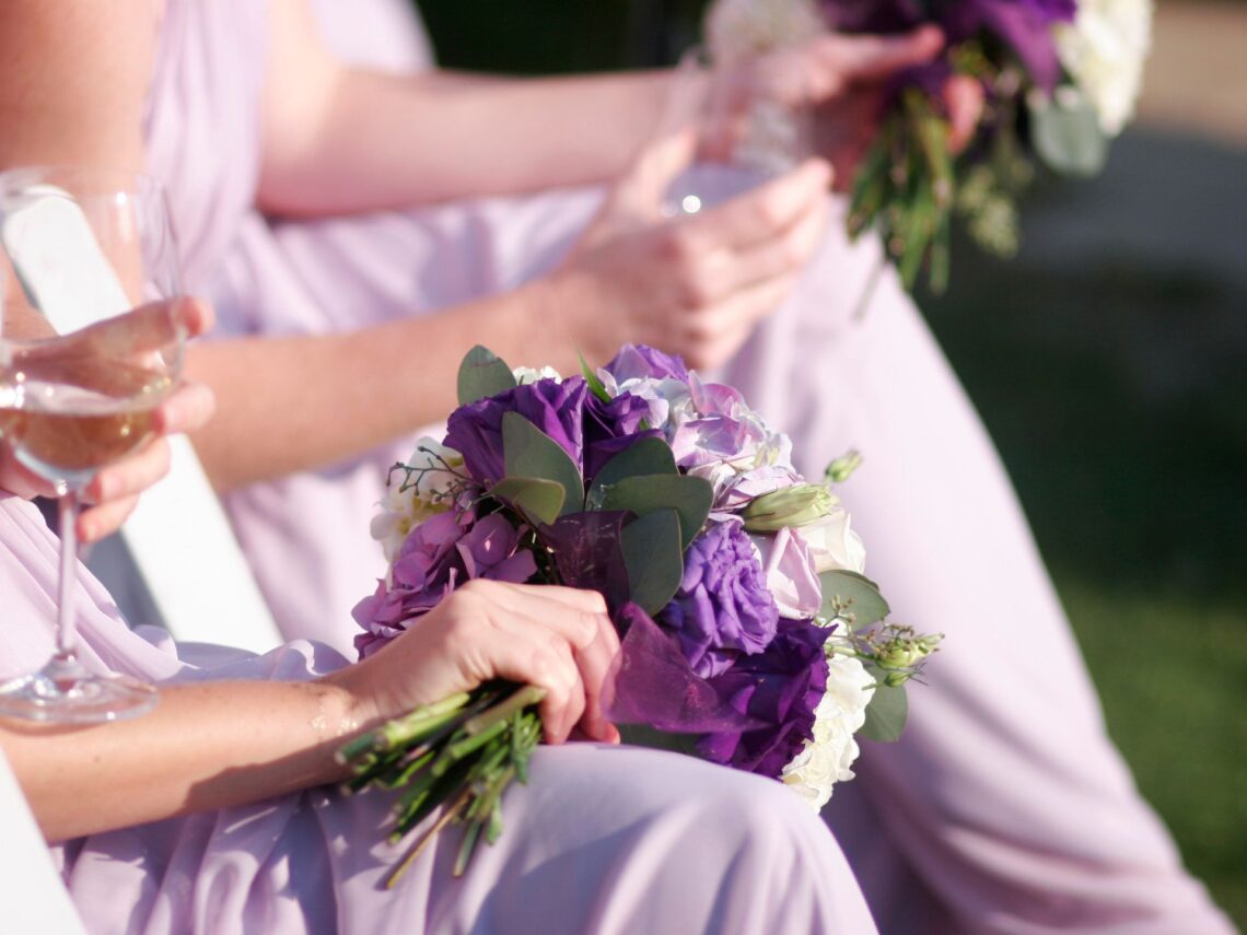 Bridesmaids wearing a lilac dress while carrying a purple bouquet.