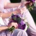 Bridesmaids wearing a lilac dress while carrying a purple bouquet.