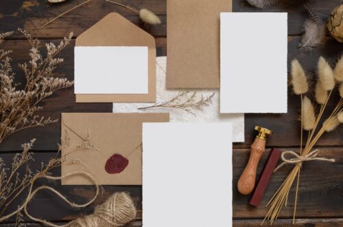 Rustic fall wedding invitations laid out on a wooden table.