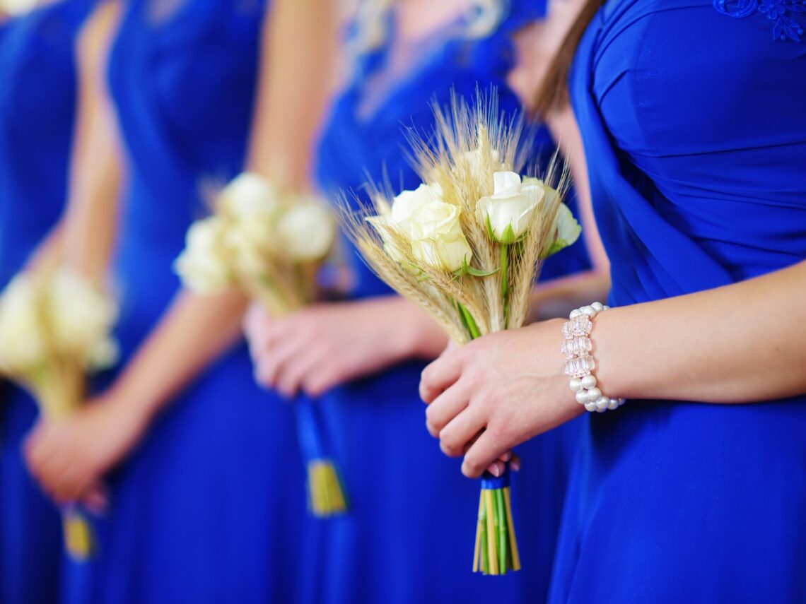 A group of bridesmaids wearing royal blue colored dresses.