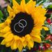 A sunflower bouquet with the wedding rings on top.