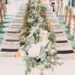 A wedding table with sage green decor on top.