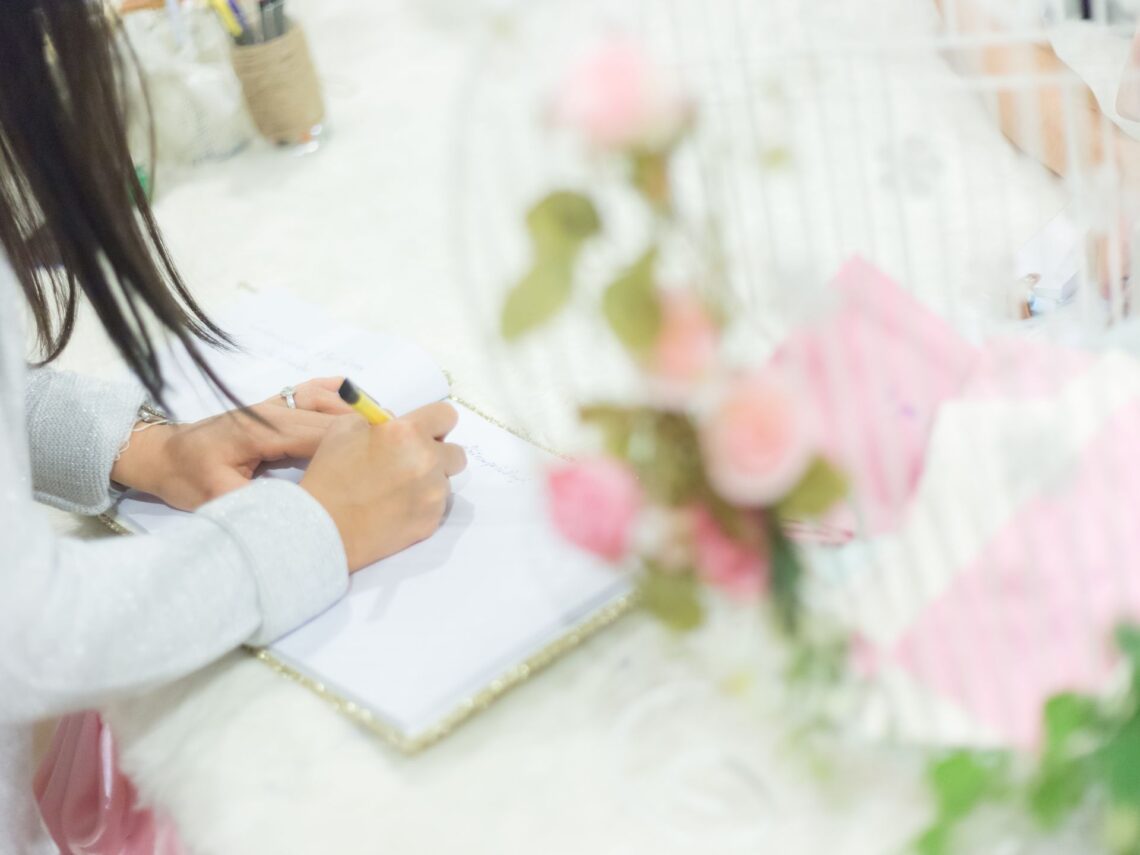 A woman at a desk writing in a binder.