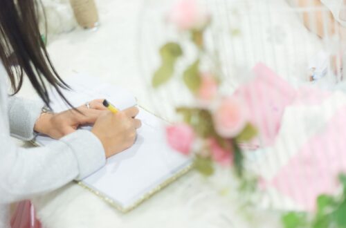 A woman at a desk writing in a binder.