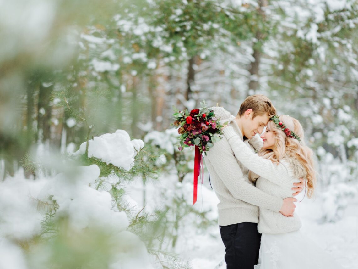 A couple taking wedding photos in the snow.