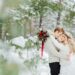 A couple taking wedding photos in the snow.