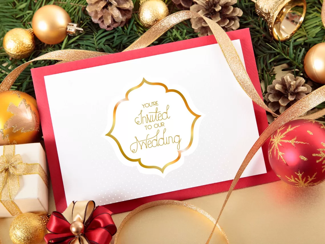 A table with ornaments and a red wedding invitation.