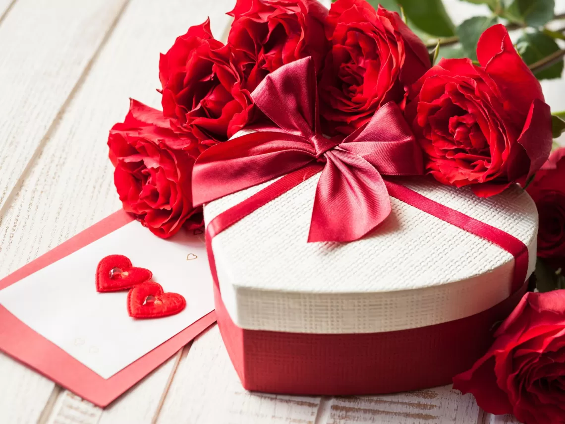 A bouquet of red rose on a table.