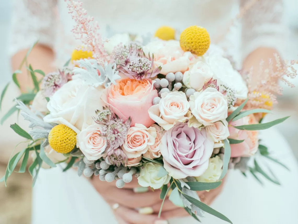 A bride holding a colorful spring wedding bouquet.