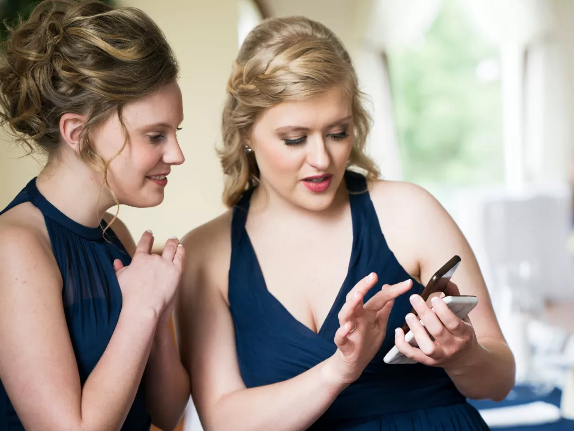 Two bridesmaids wearing navy blue colored dresses.